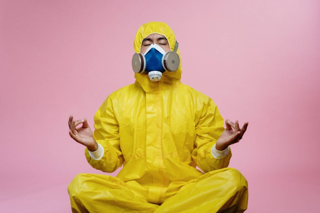 man meditating in yellow protective suit