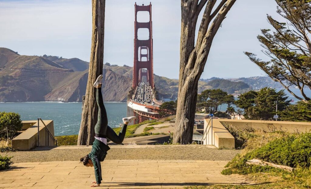 happy woman break-dancing near the Golden Gate Bridge