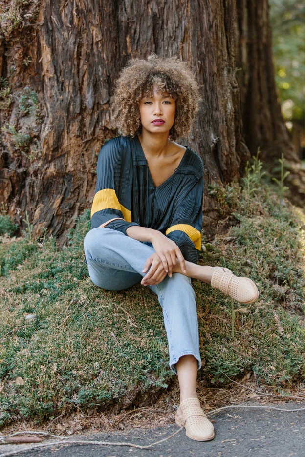 Woman with Curly Hair Sitting in Sweater and Jeans from Two Birds