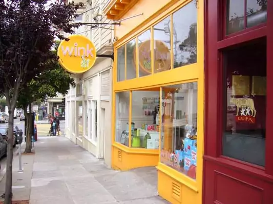 Brightly Yellow Painted Store Along Sidewalk In Noe Valley With Wink SF Sign