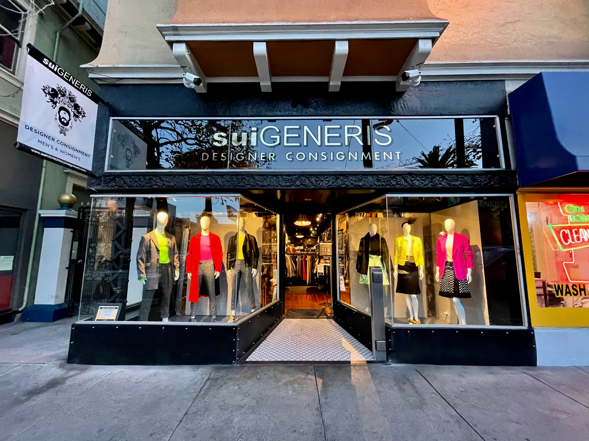 Sidewalk view of Sui Generis Designer Consignment with mannequins dressed in vintage consignment pieces