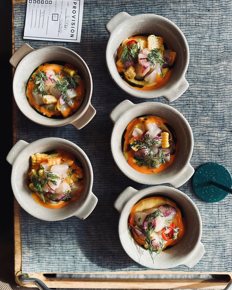 5 Bowls of Hokkaido scallop tartare topped with herbs and sliced radish arranged on a serving tray at State Bird Provisions