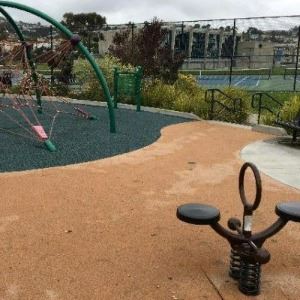 Close up of kids playground at Balboa Park with tennis courts in the background