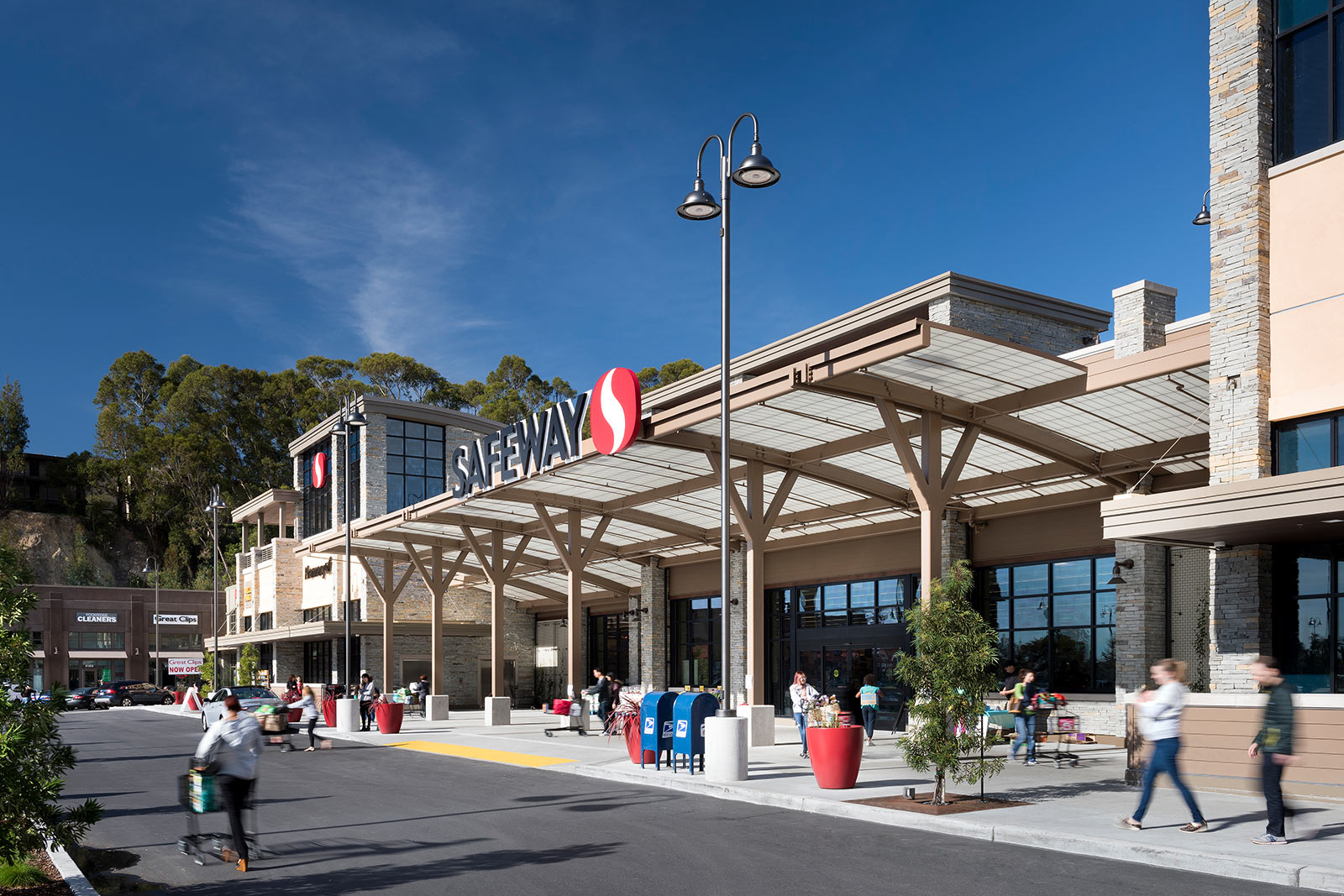 Parking Lot view of Safeway Storefront with a Great Clips and drycleaning shop in the background at new retail plaza The Ridge in Oakland