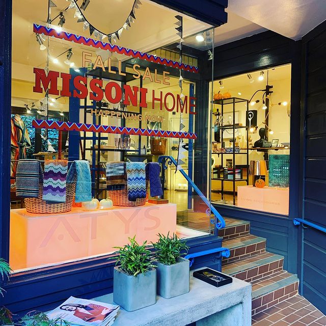 Exterior view of blue ATYS storefront with window lettering stating “Fall Salle Missoni Home Happening Now”