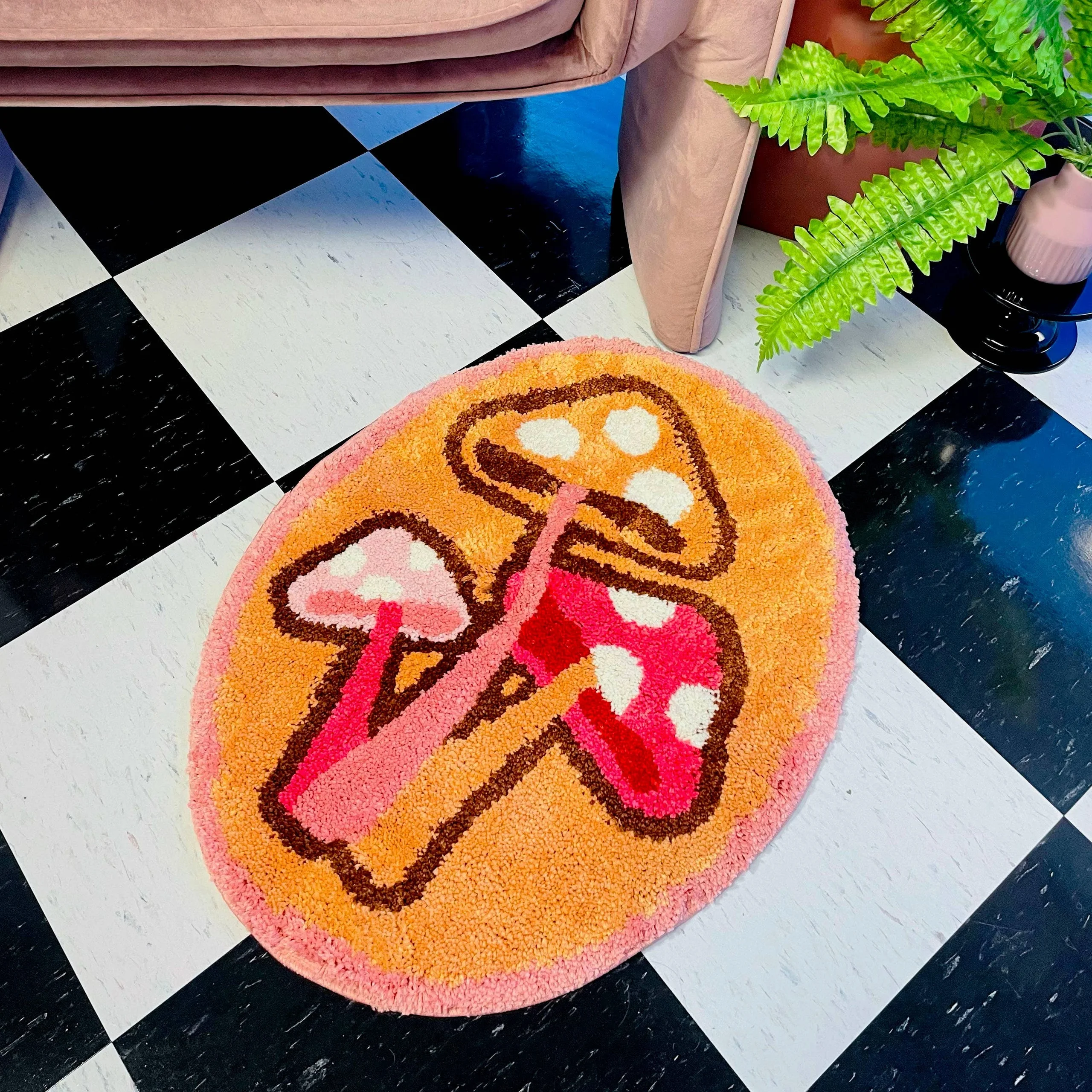 Orange, Pink, and White bath rug with three mushrooms on a white and black square tiled floor