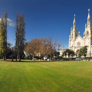 Expansive open green lawn space at Washington Square Park with view of Saints Peter and Paul Church in background