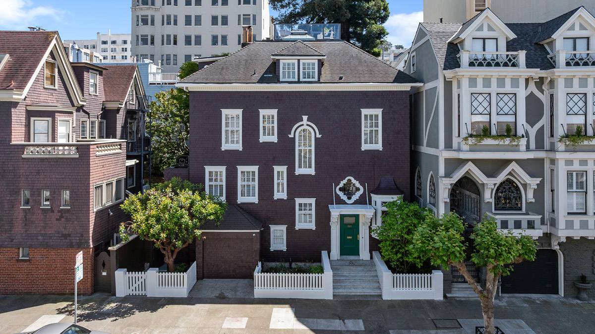 Front exterior of a stately shingled Pacific Heights home in San Francisco with white trim, a green front door, and a white picket fence, recently sold by Danielle Lazier of Vivre Real Estate